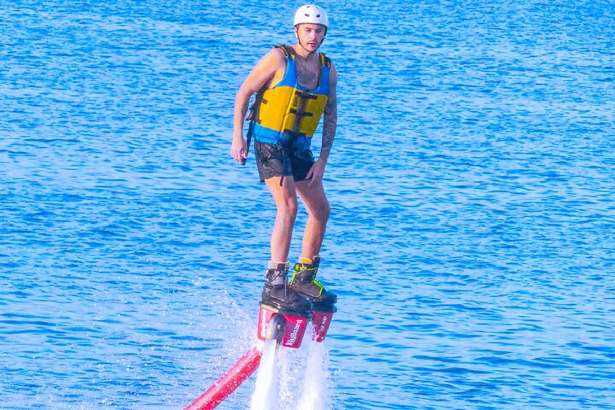 en mann står på et surfebrett i vannet