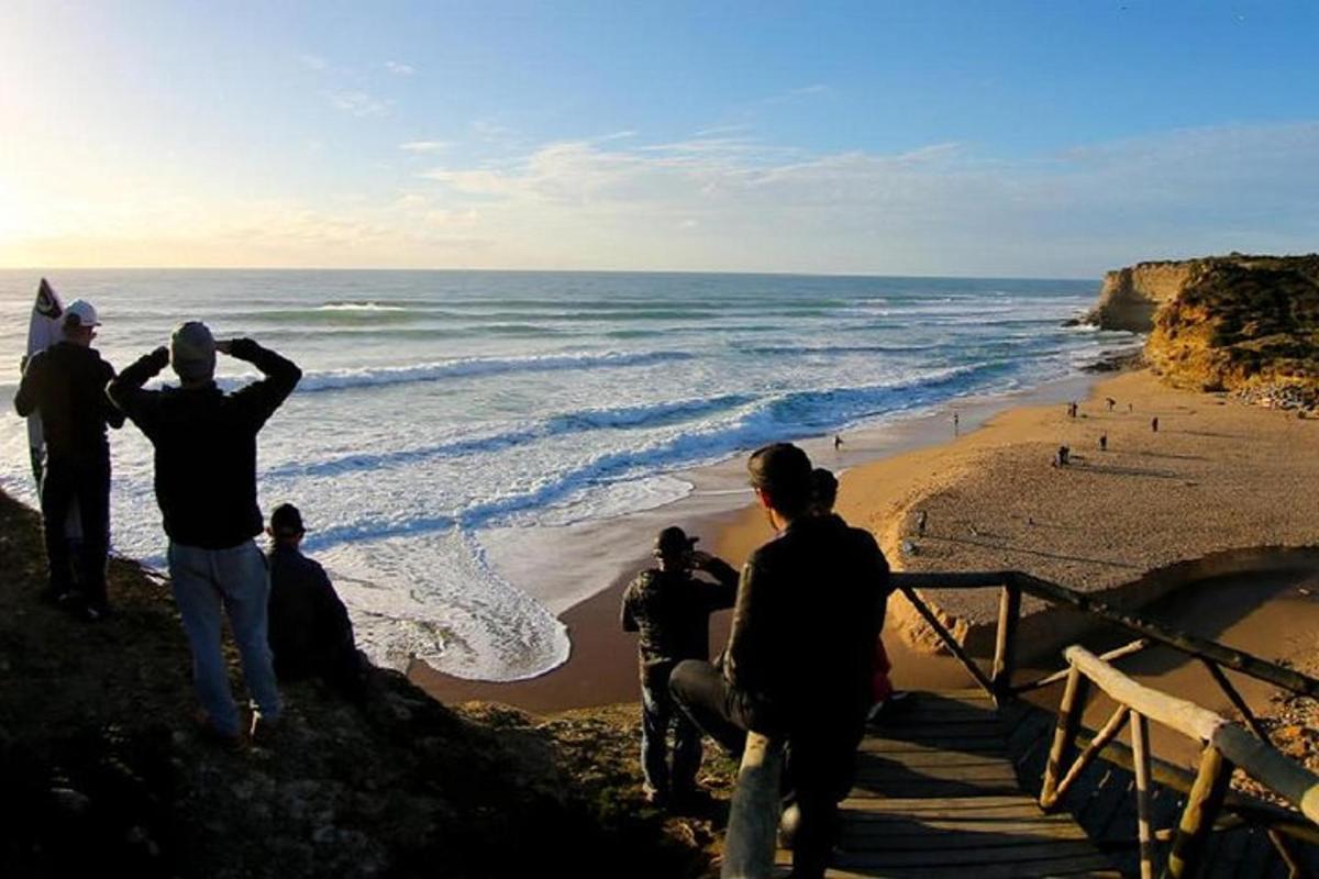 um grupo de pessoas em pé nos degraus da praia