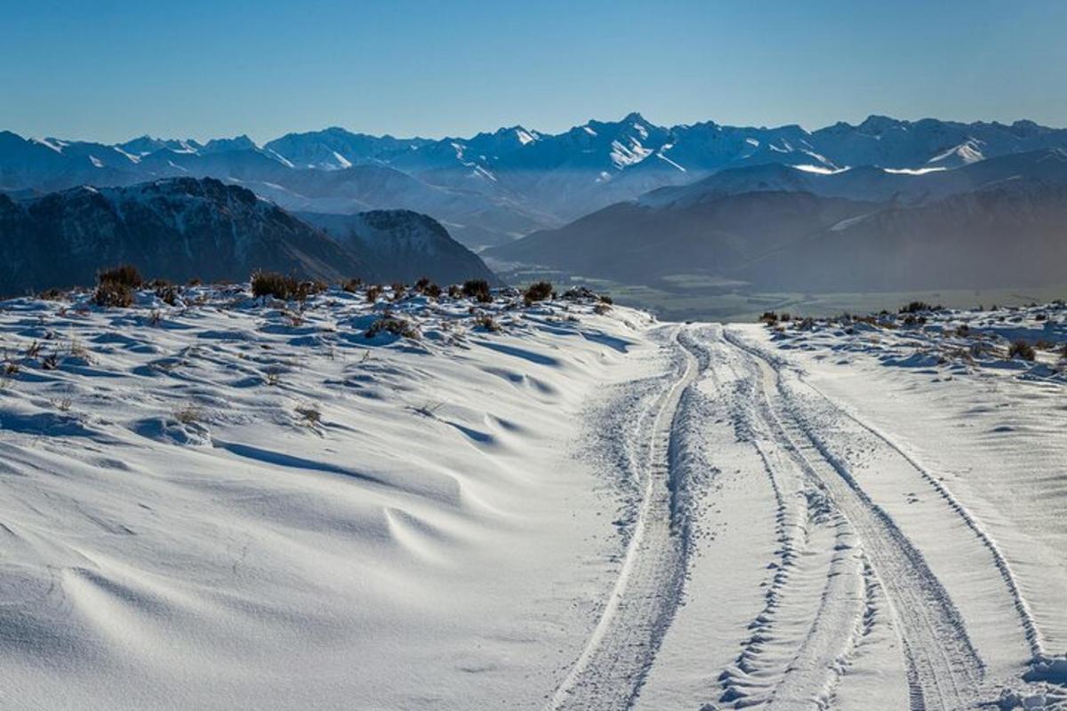 uma montanha coberta de neve com pegadas na neve