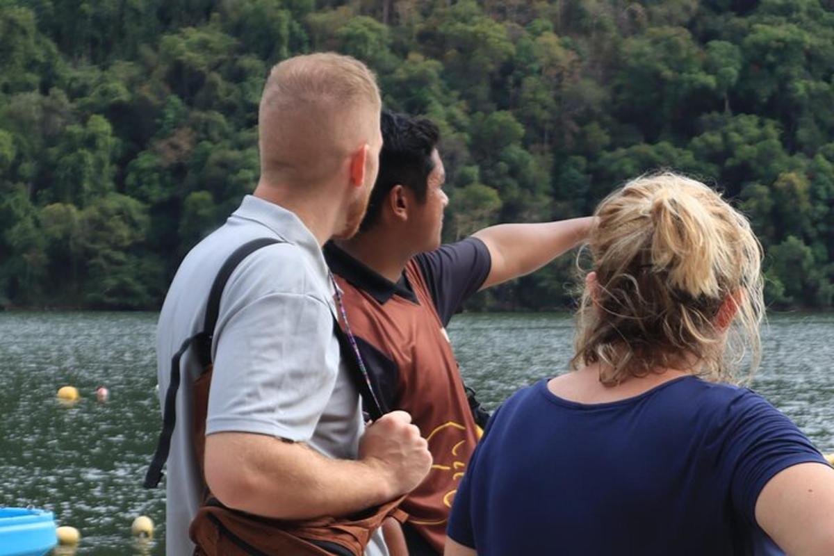 Un grupo de tres personas de pie frente a un lago.