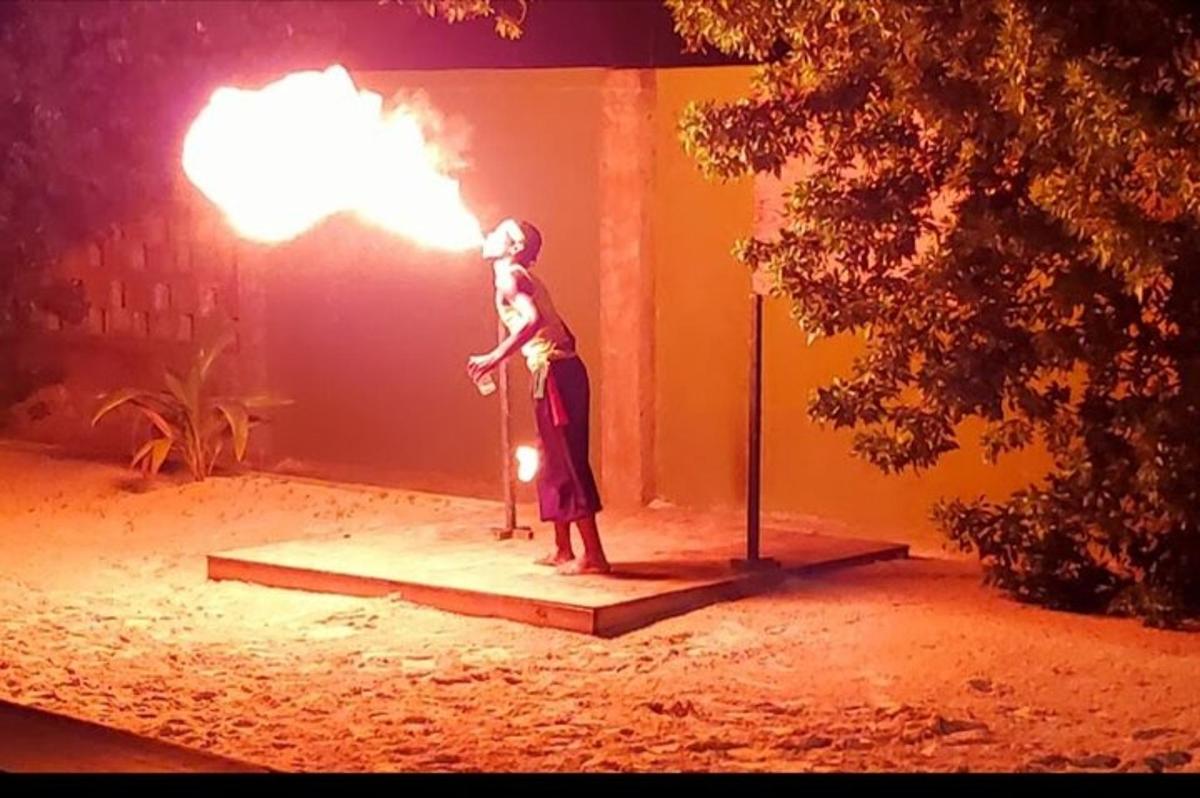 Un hombre de pie en un escenario con un fuego.