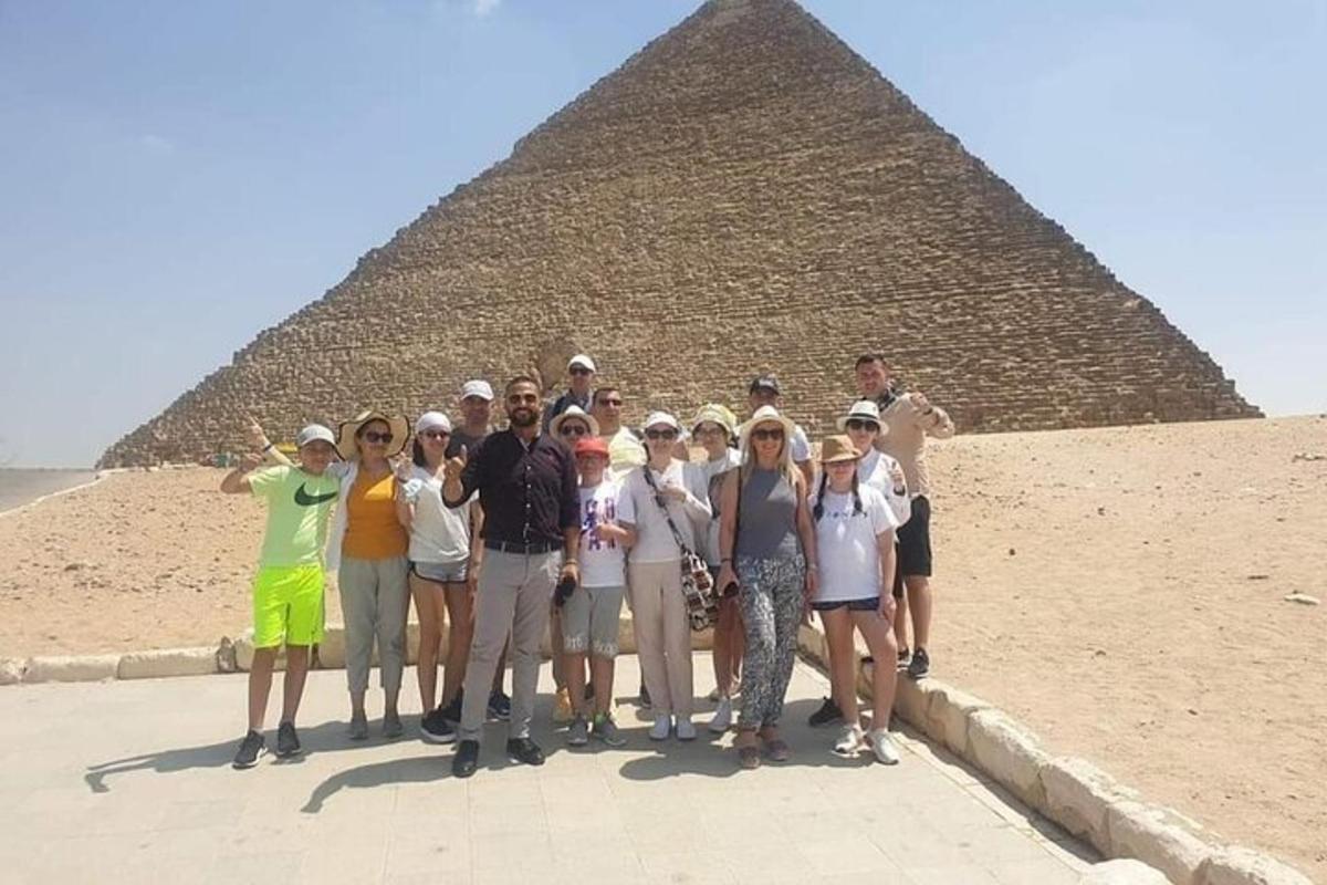 skupina lidí stojící před pyramidou