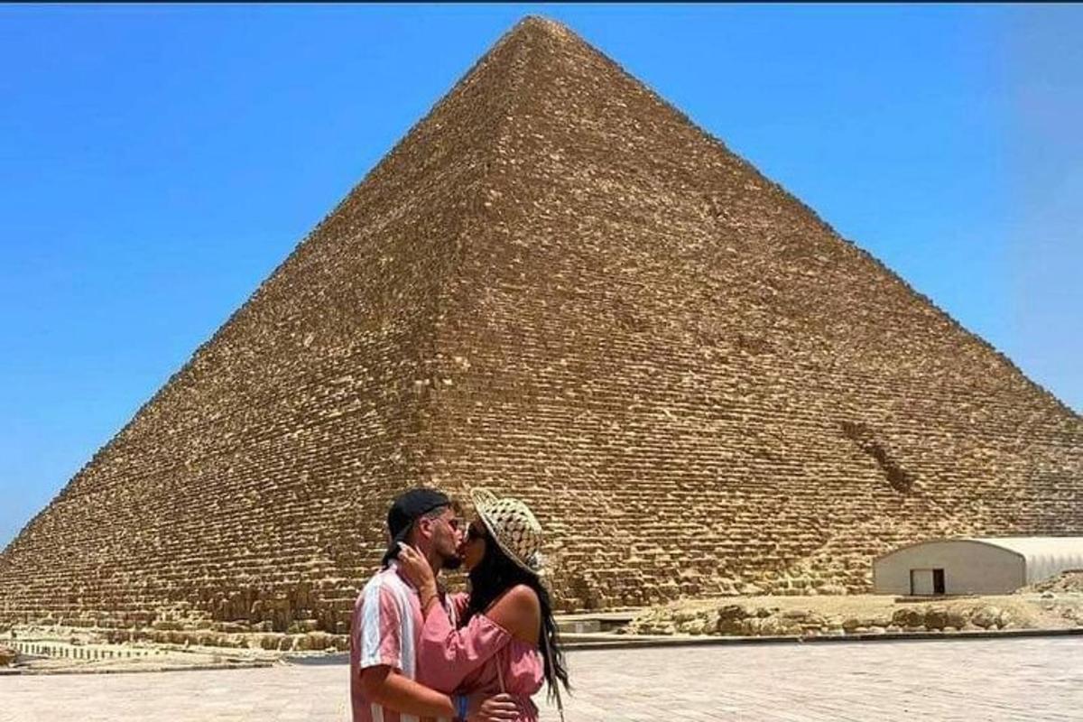 dva lidé stojící před pyramidou