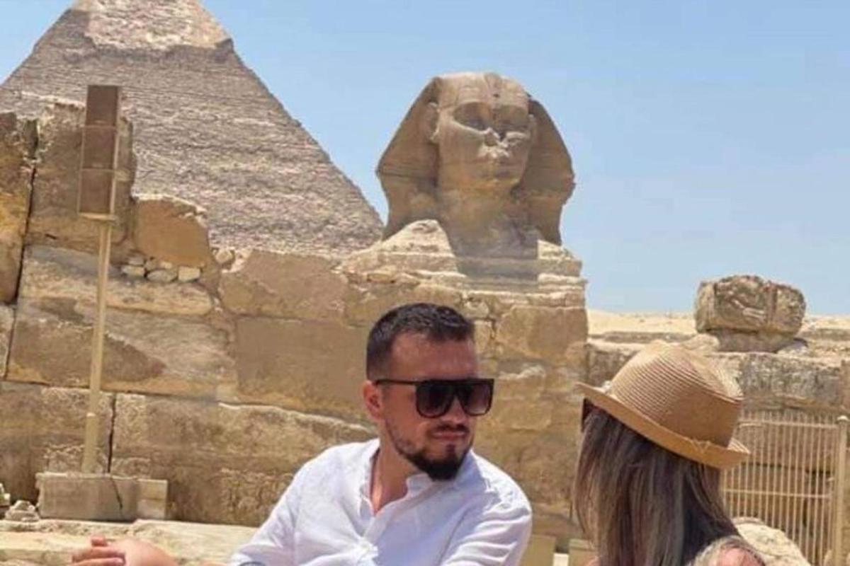 Ένας άνδρας και μια γυναίκα στέκονται μπροστά στις πυραμίδες