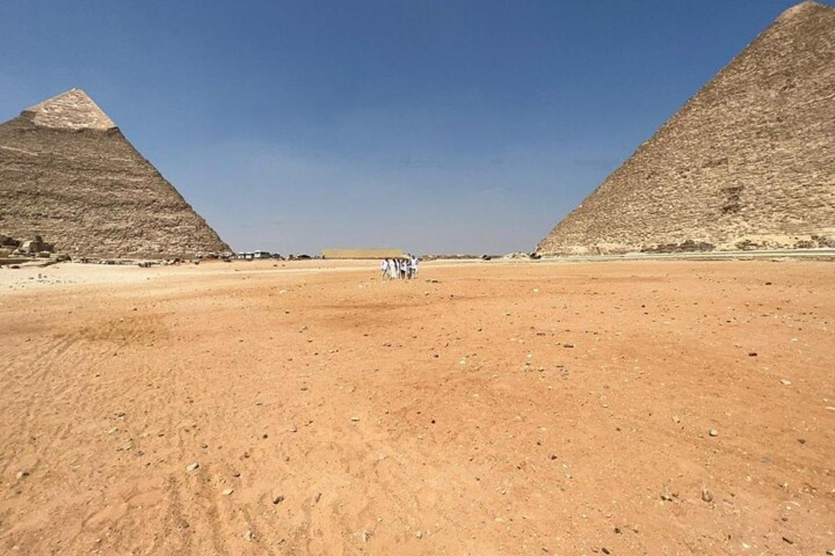 skupina lidí stojící před pyramidami