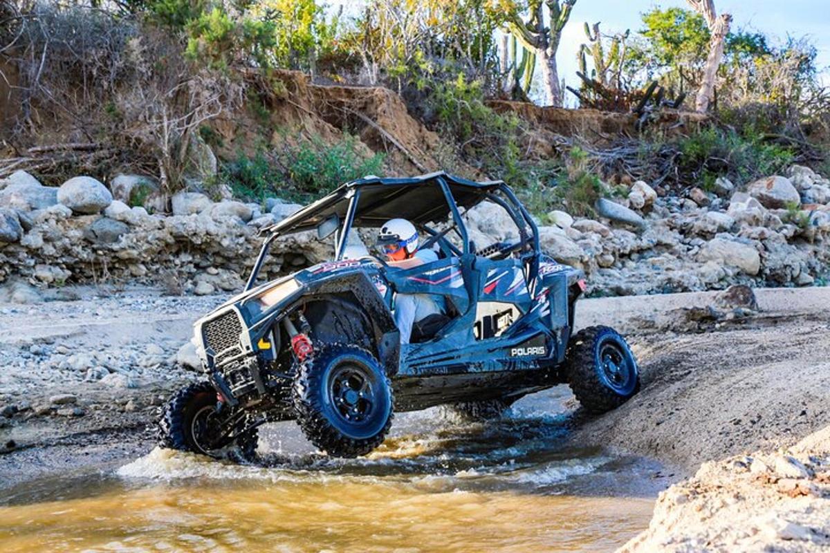 una persona conduint un quad a l'aigua