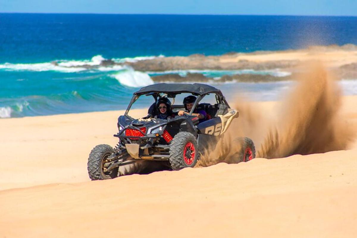 dues persones que viatgen en un quad a la platja