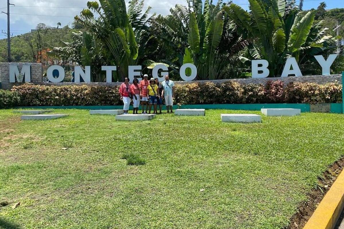 un gruppo di persone in piedi davanti a un cartello