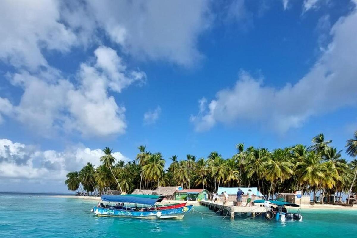 two boats in the water near a beach with palm trees