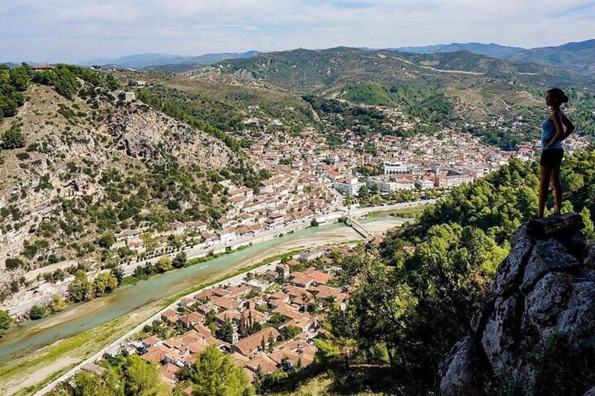 o persoană care stă pe vârful unui munte și domină un oraș