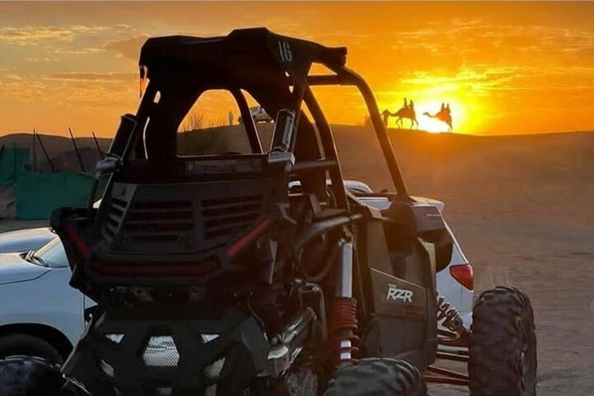 sebuah traktor di padang pasir dengan latar belakang matahari terbenam