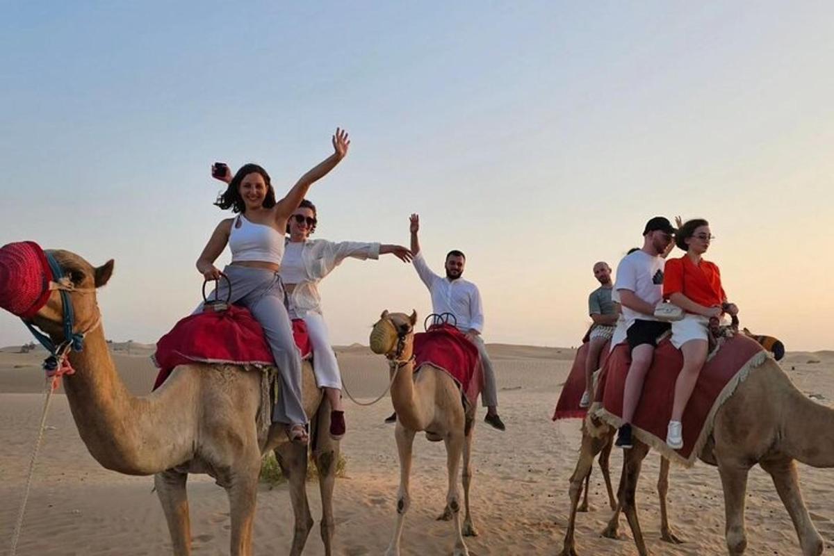 un gruppo di persone a cavallo di cammelli nel deserto