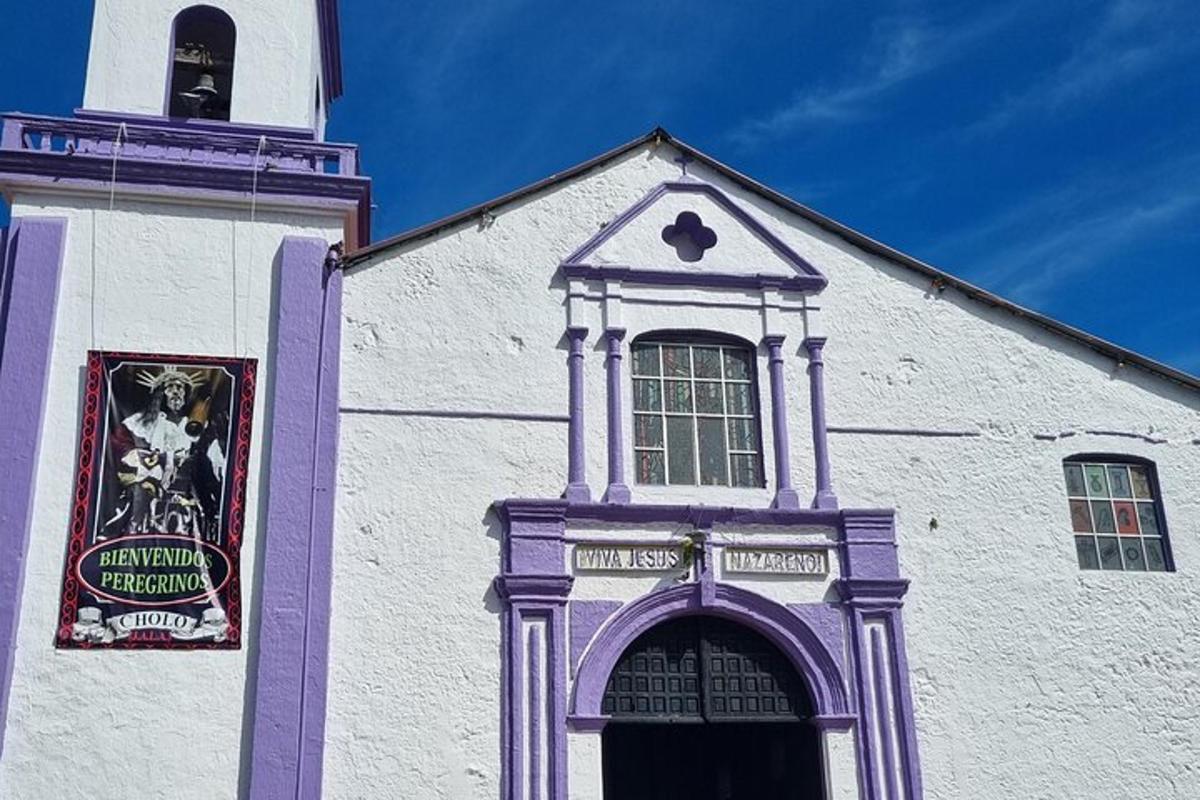 una chiesa viola e bianca con una torre dell'orologio