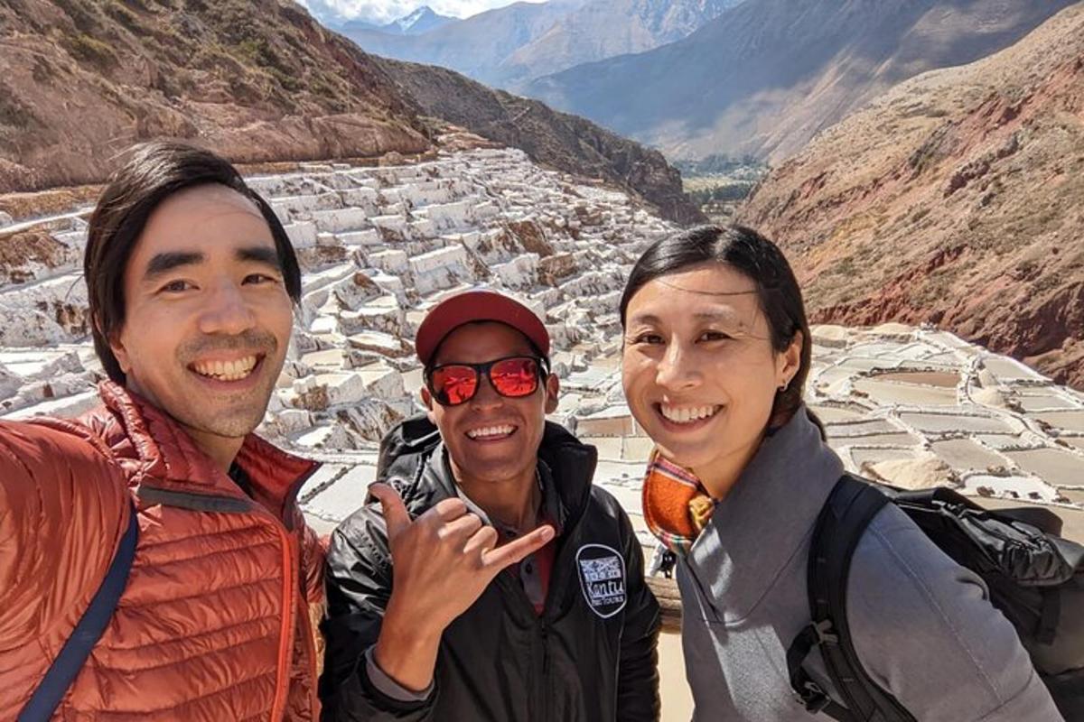 un gruppo di tre persone in piedi sulla cima di una montagna