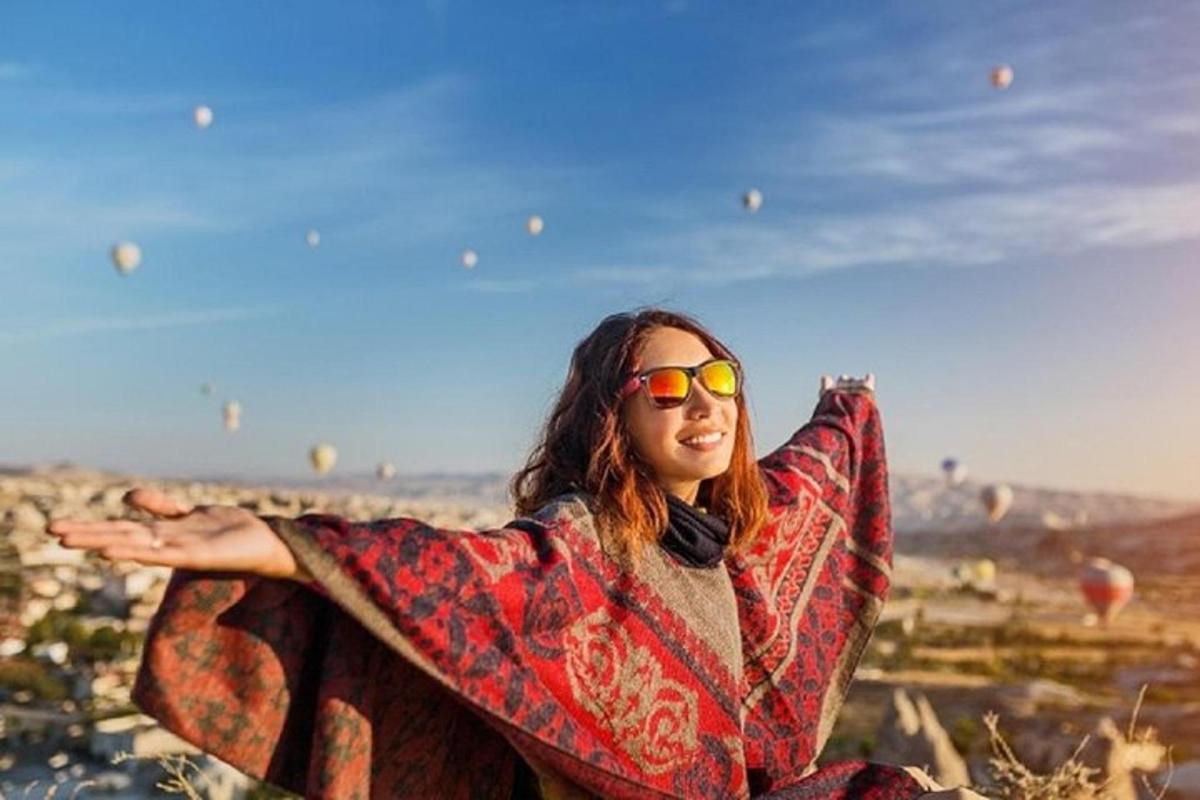 una dona amb ulleres de sol asseguda al cim d'un turó