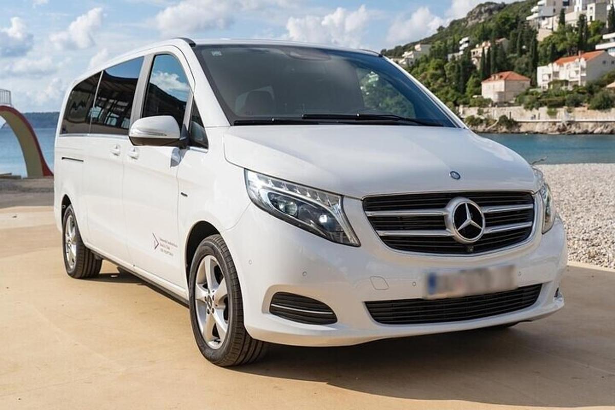 белый фургон Mercedes-Benz, припаркованный рядом с пляжем