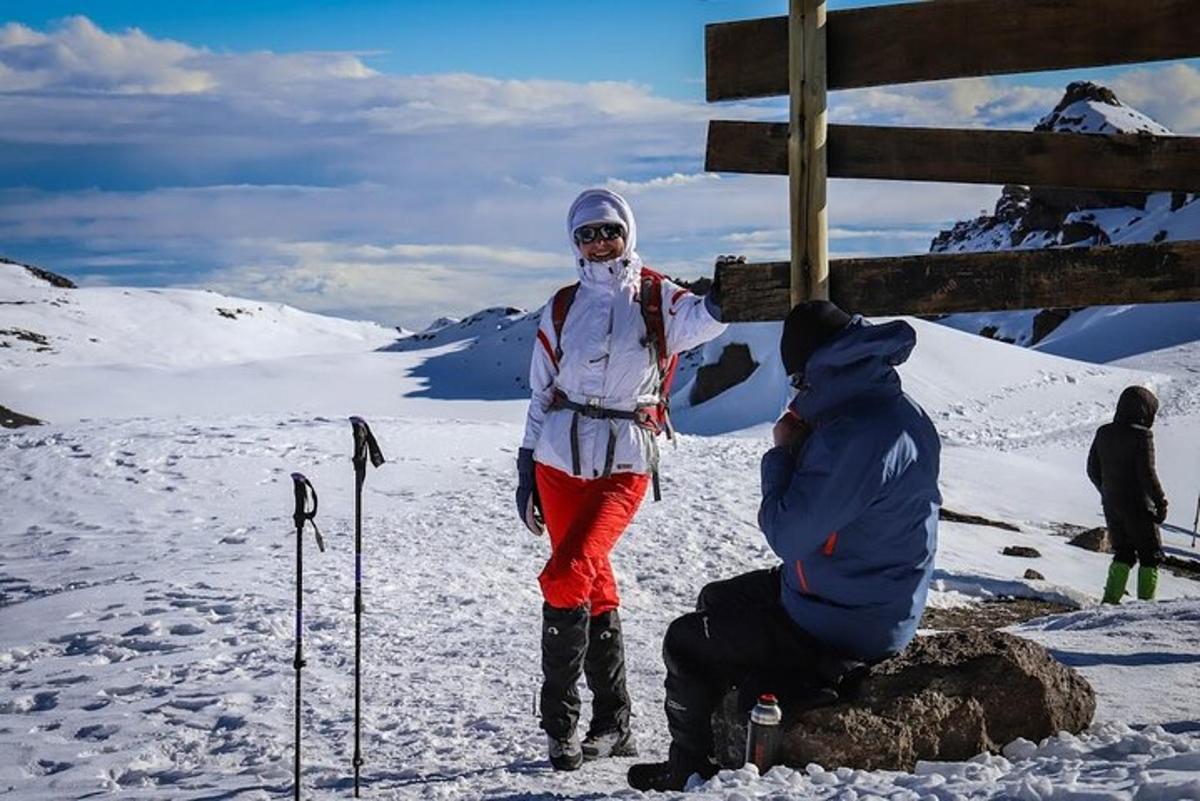 žena stojící na vrcholu zasněžené hory