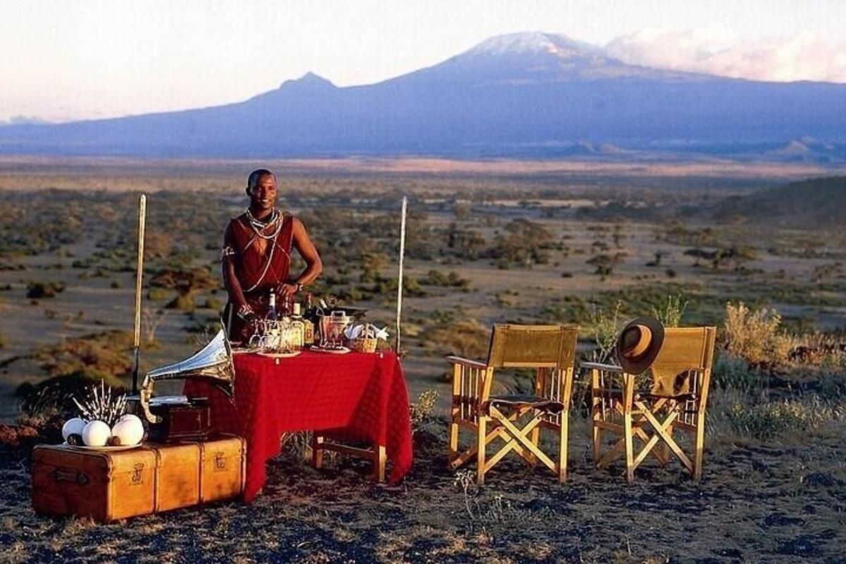 a man standing next to a table in the desert