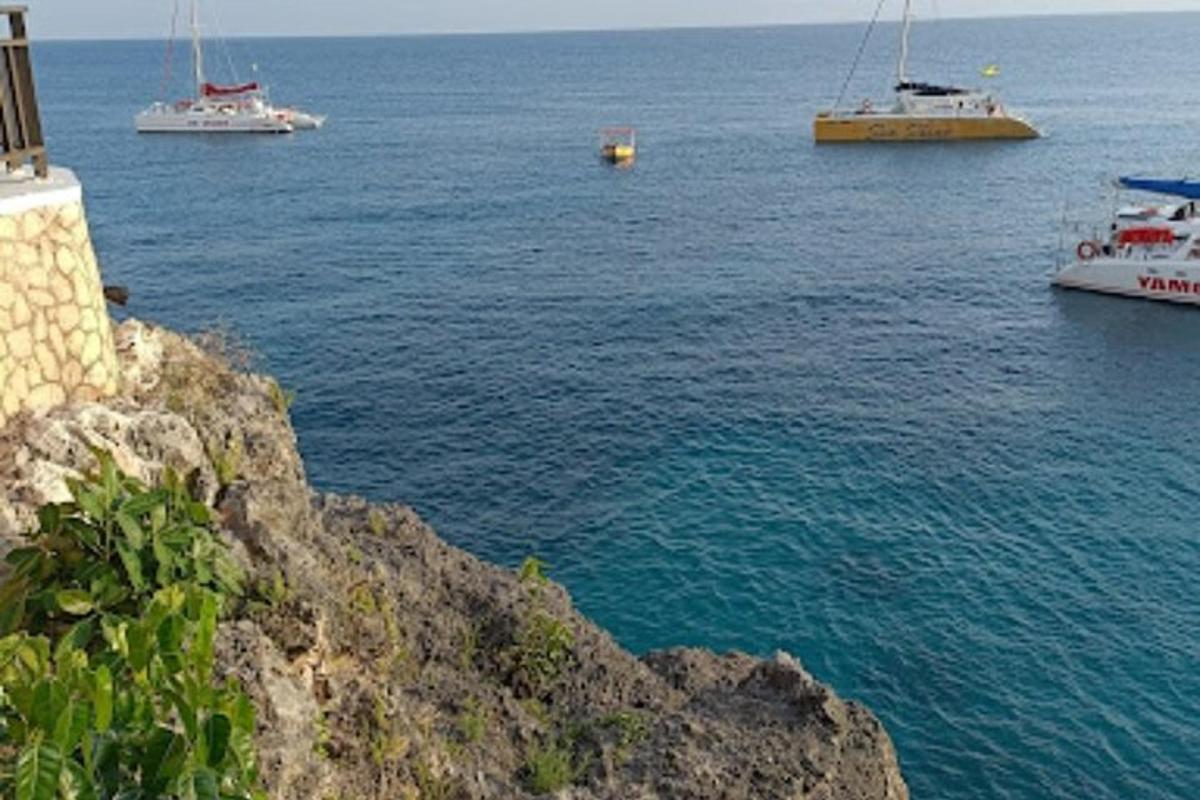 Μια ομάδα σκαφών στο νερό κοντά σε έναν απότομο βράχο