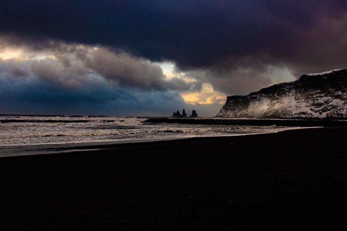 a beach with a cloudy sky and the ocean