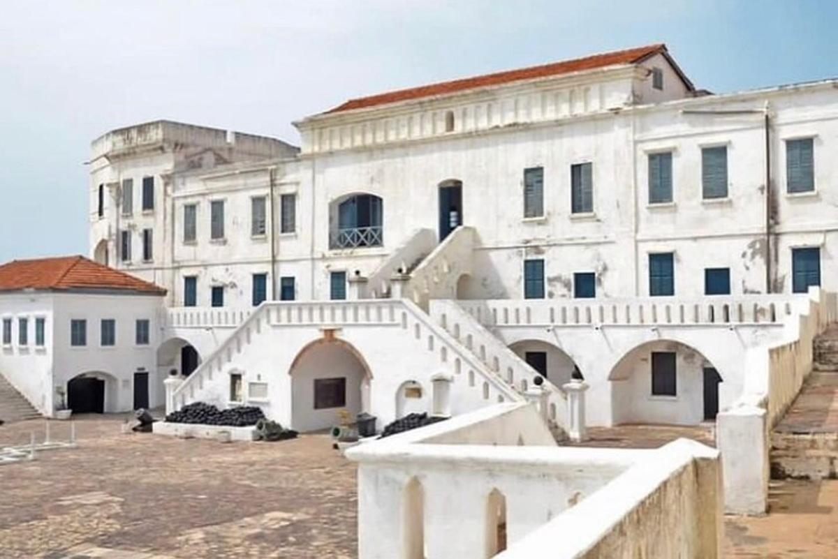 un grande edificio bianco con delle scale di fronte