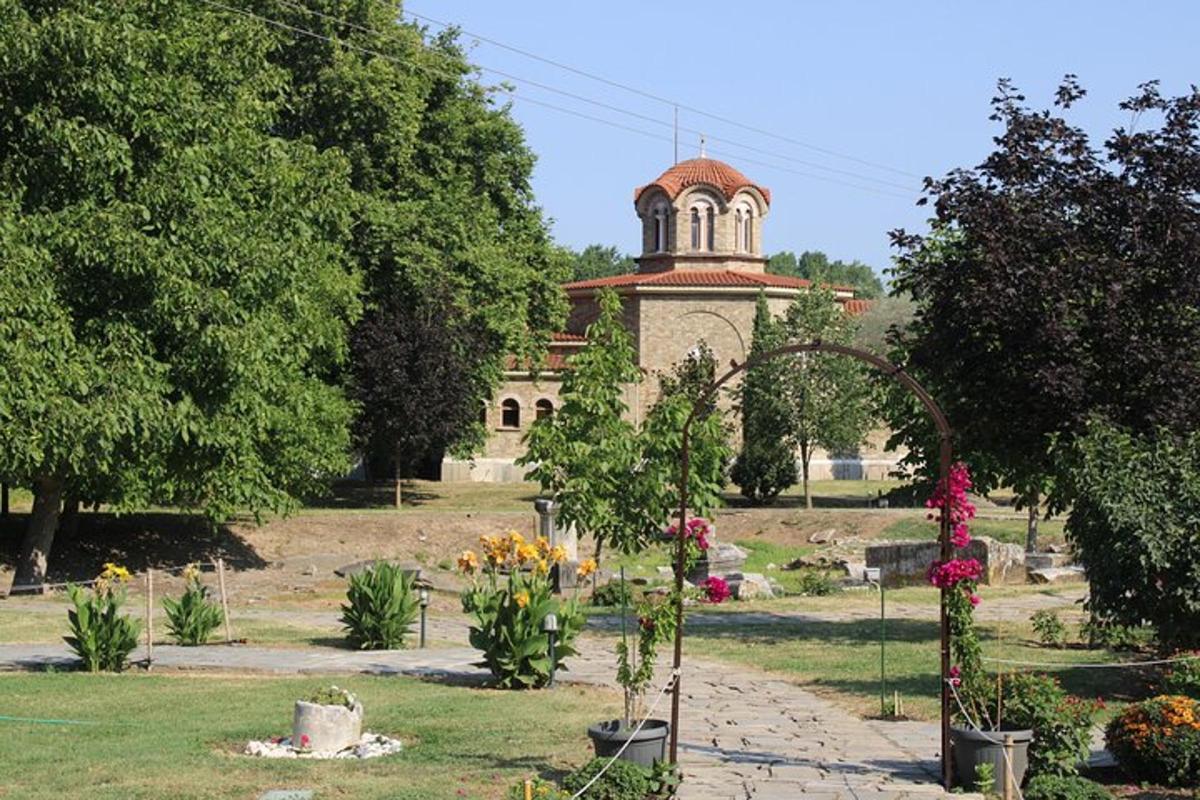 ένας κήπος με ένα κτίριο στο φόντο με λουλούδια