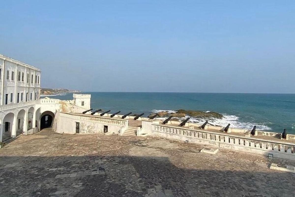 un edificio vicino all'oceano con degli uccelli sopra