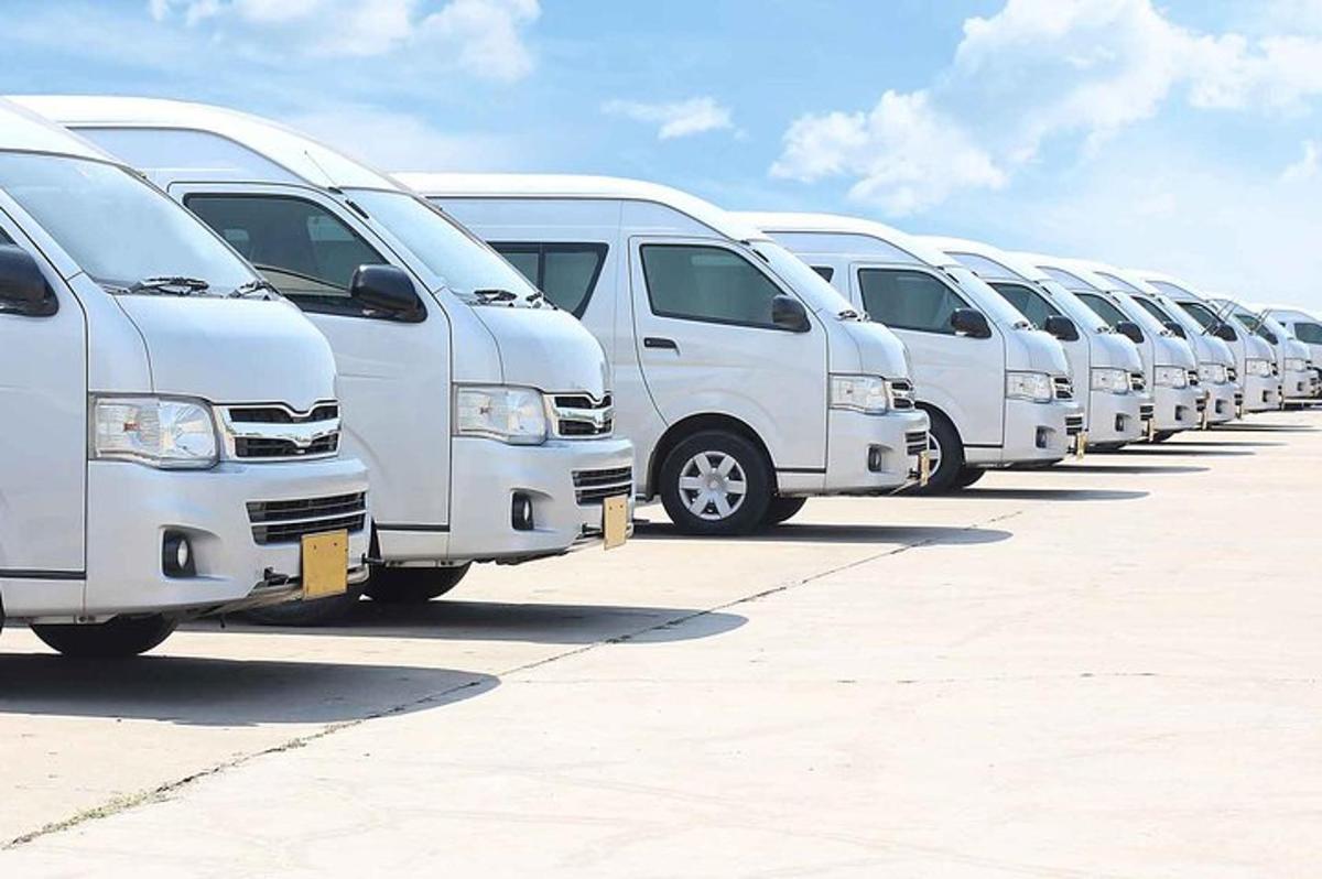 isang hilera ng mga puting van na nakaparada sa isang parking lot