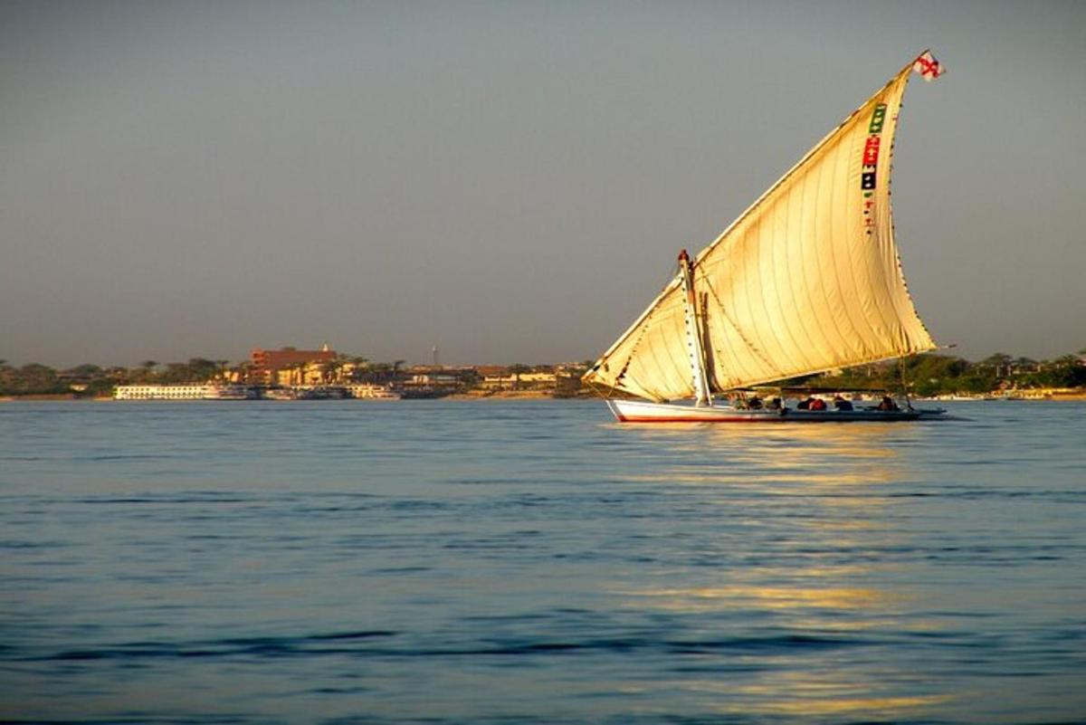 un barco con una gran vela amarilla en el agua