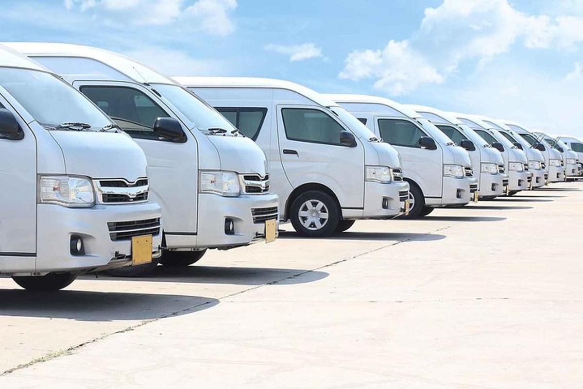 Una fila de furgonetas blancas estacionadas en un estacionamiento