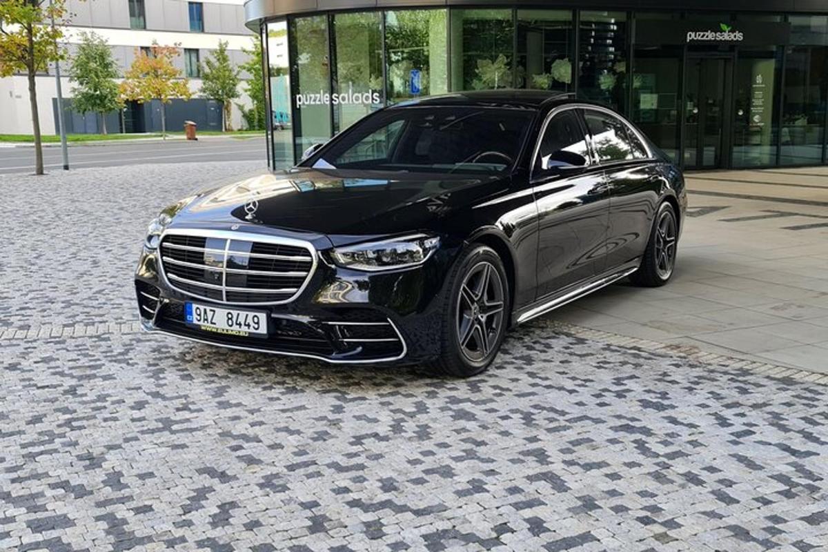 um carro preto estacionado em uma rua de paralelepípedos