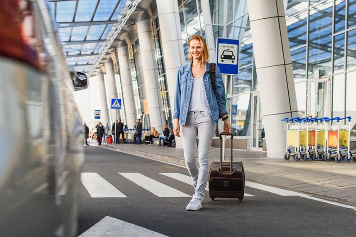 a woman walking down a street with a suitcase