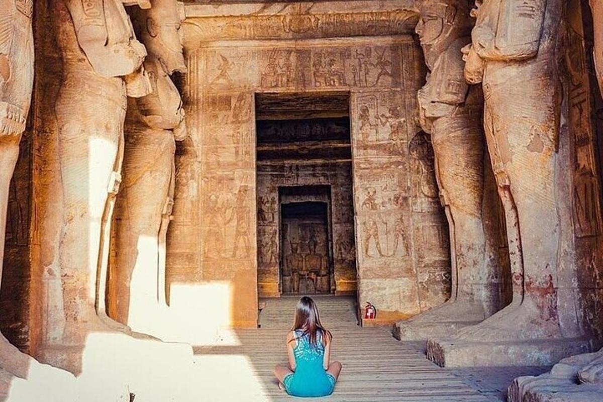 a woman sitting on the steps of an ancient building