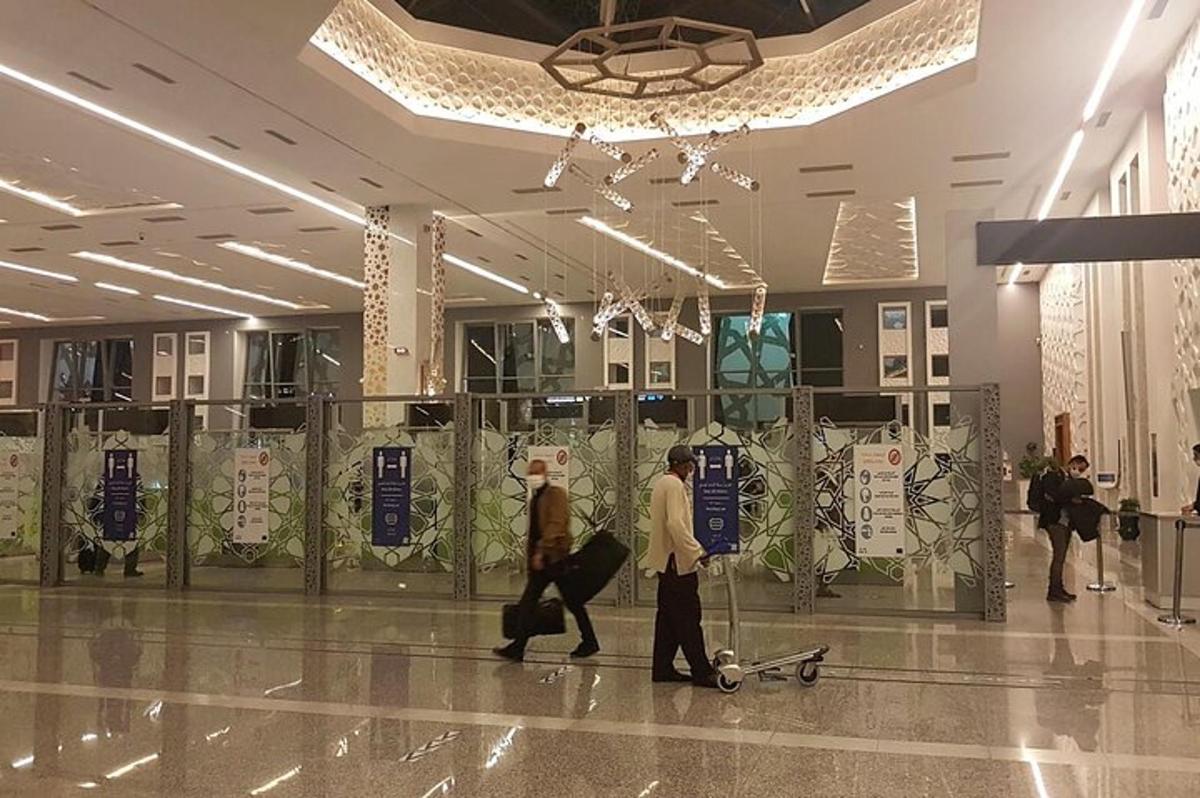 due persone che camminano in un aeroporto con i loro bagagli