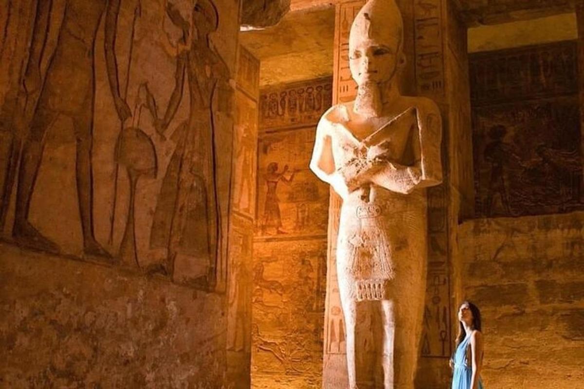 en kvinne som står ved siden av en statue i et museum