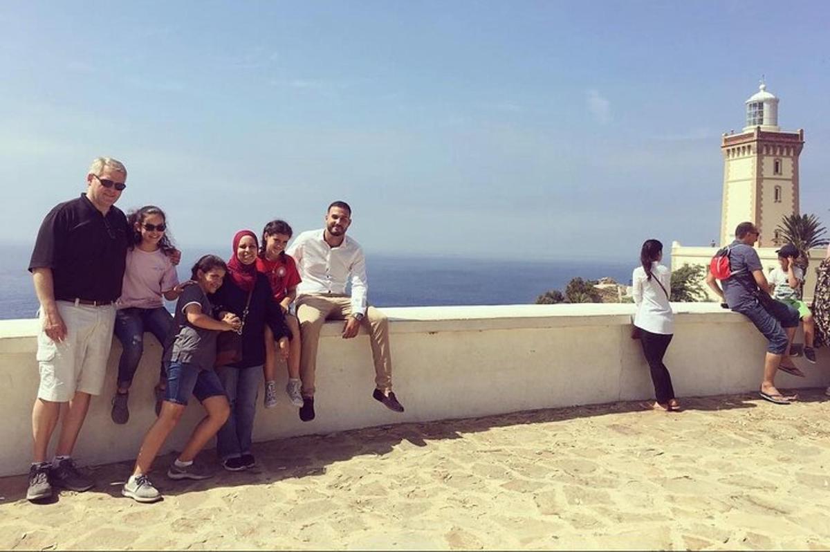 un gruppo di persone sedute su un muro vicino all'oceano