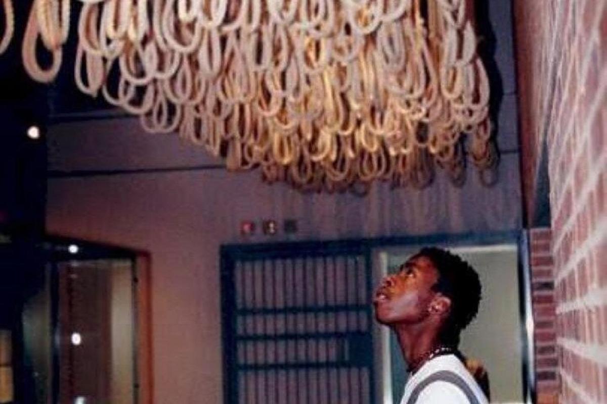 um homem está parado sob um lustre