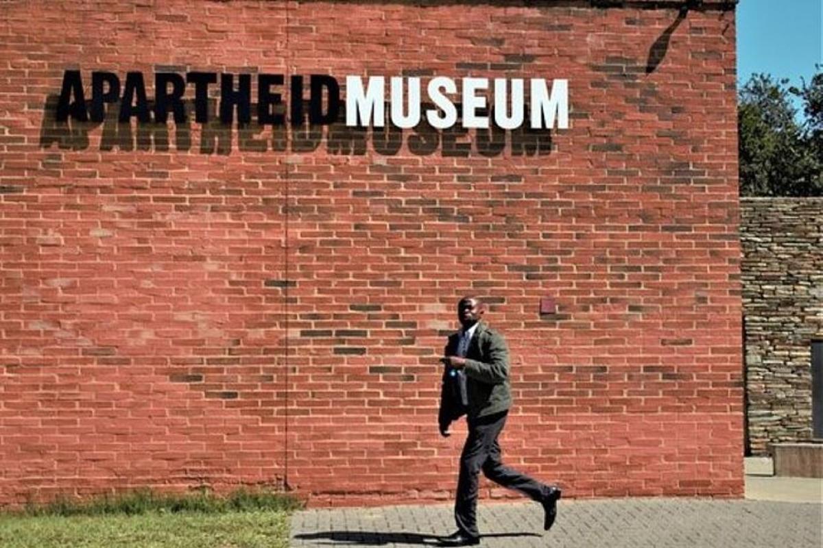 um homem está passando por um muro de tijolos