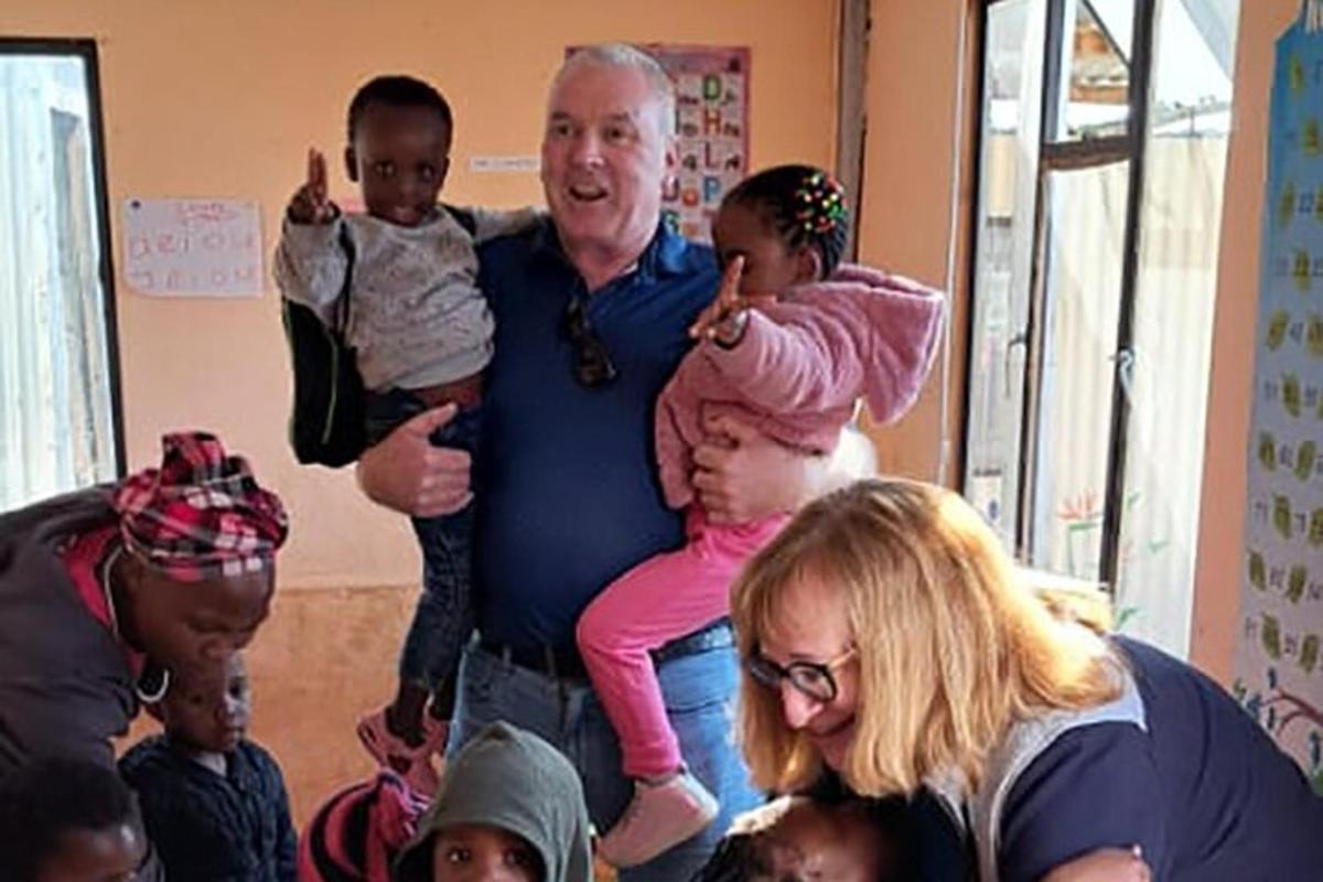 a man is holding two children on his shoulders
