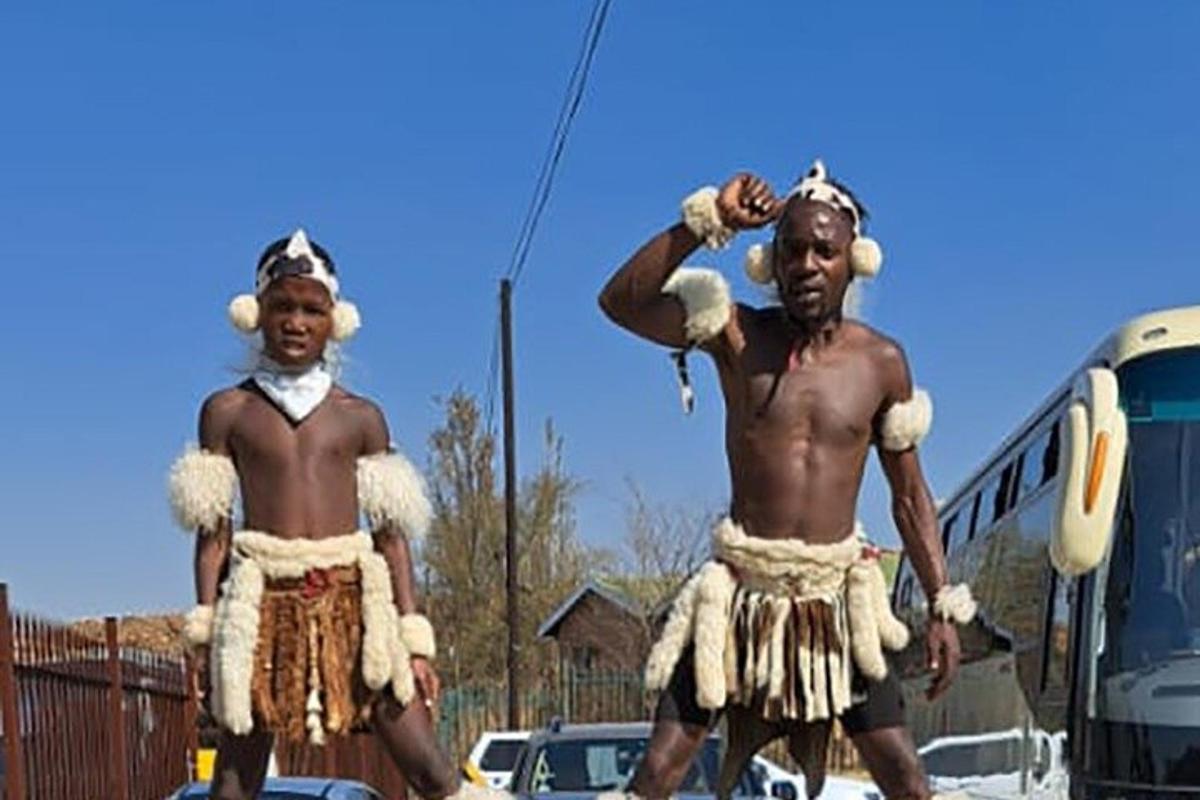 two men in costumes standing in front of a bus