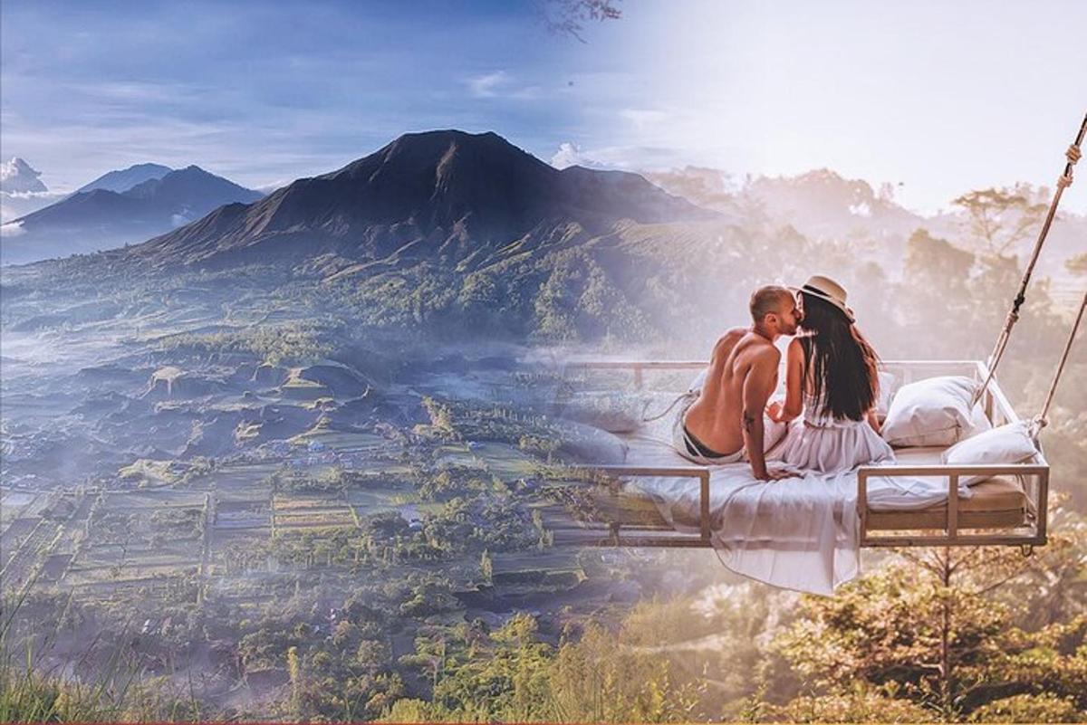 a couple sitting on a swing overlooking a mountain