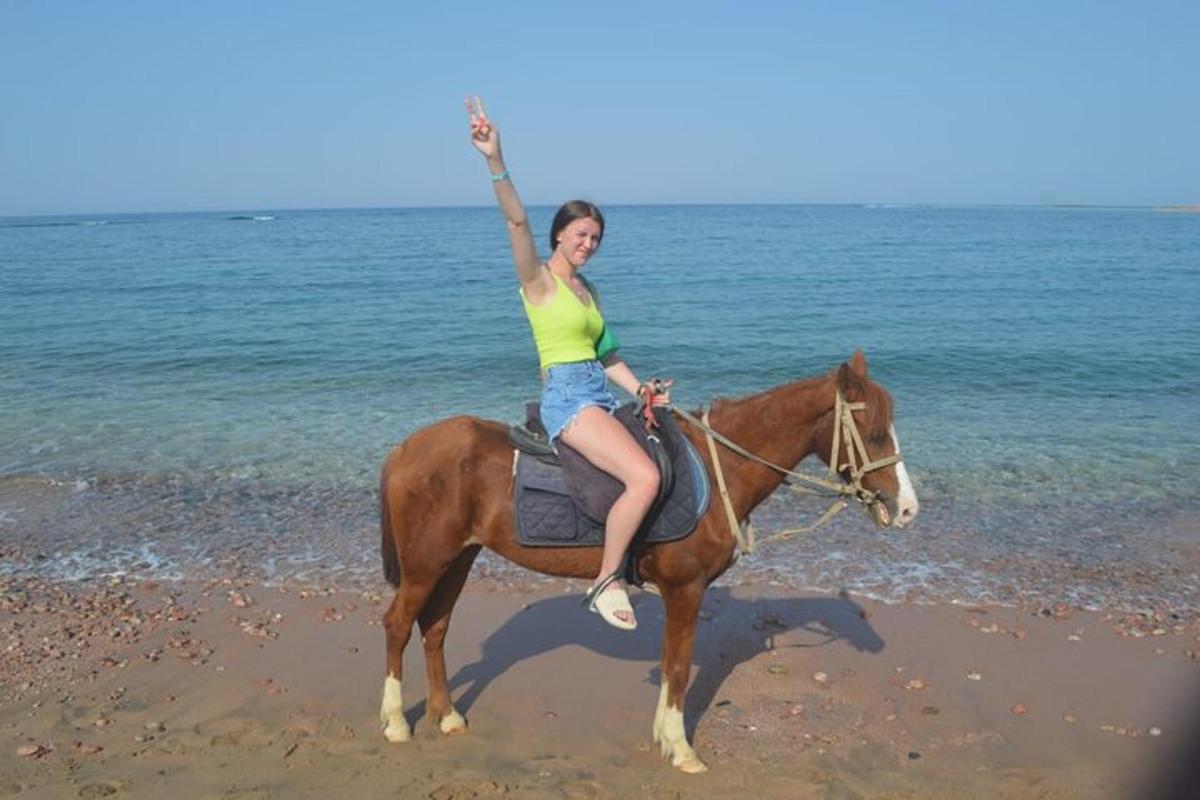 una donna a cavallo sulla spiaggia