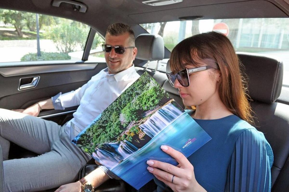 muž a žena sedící v autě a dívající se na knihu