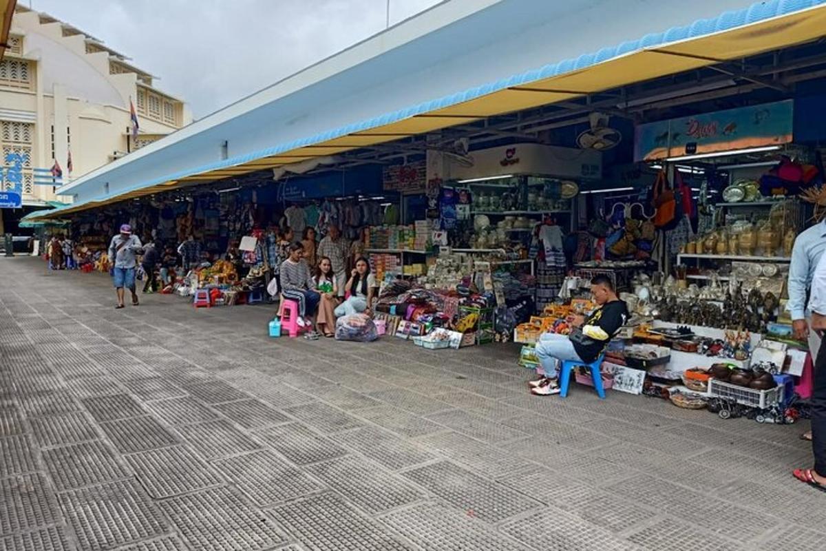 Un mercado con gente sentada frente a una tienda.