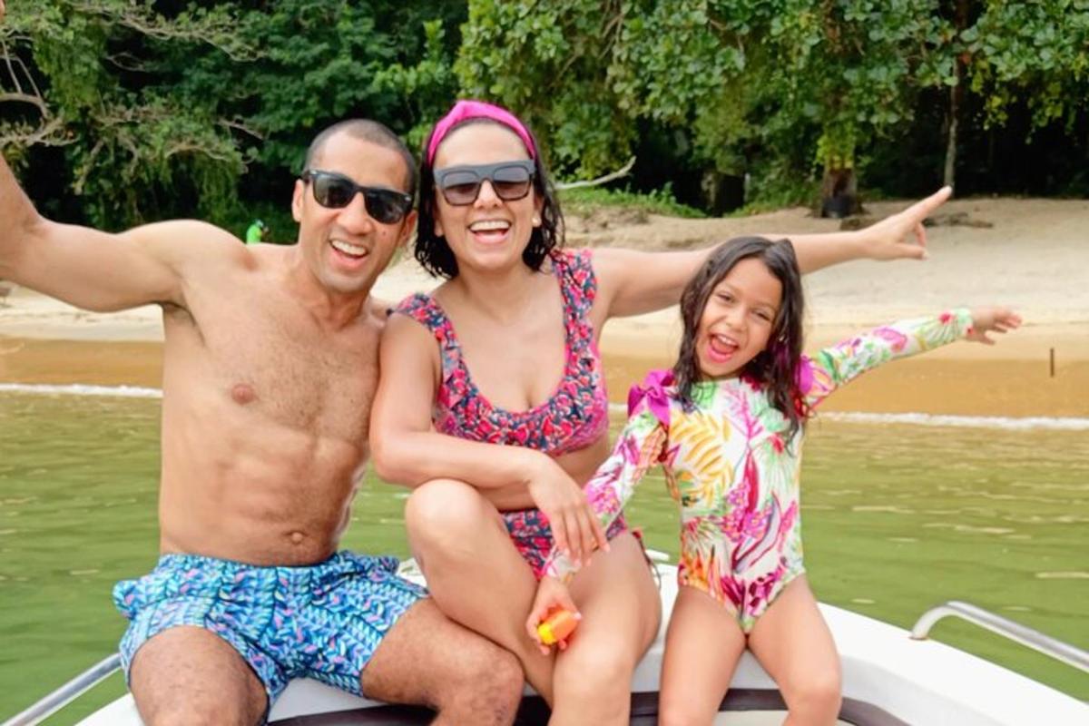 isang lalaki at dalawang babae na nakasuot ng bathing suit sa isang bangka