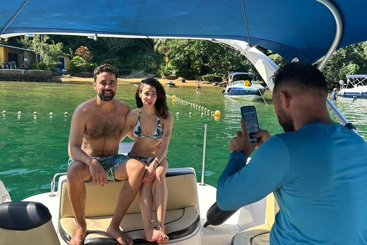 isang lalaki na kumukuha ng larawan ng dalawang tao sa isang bangka