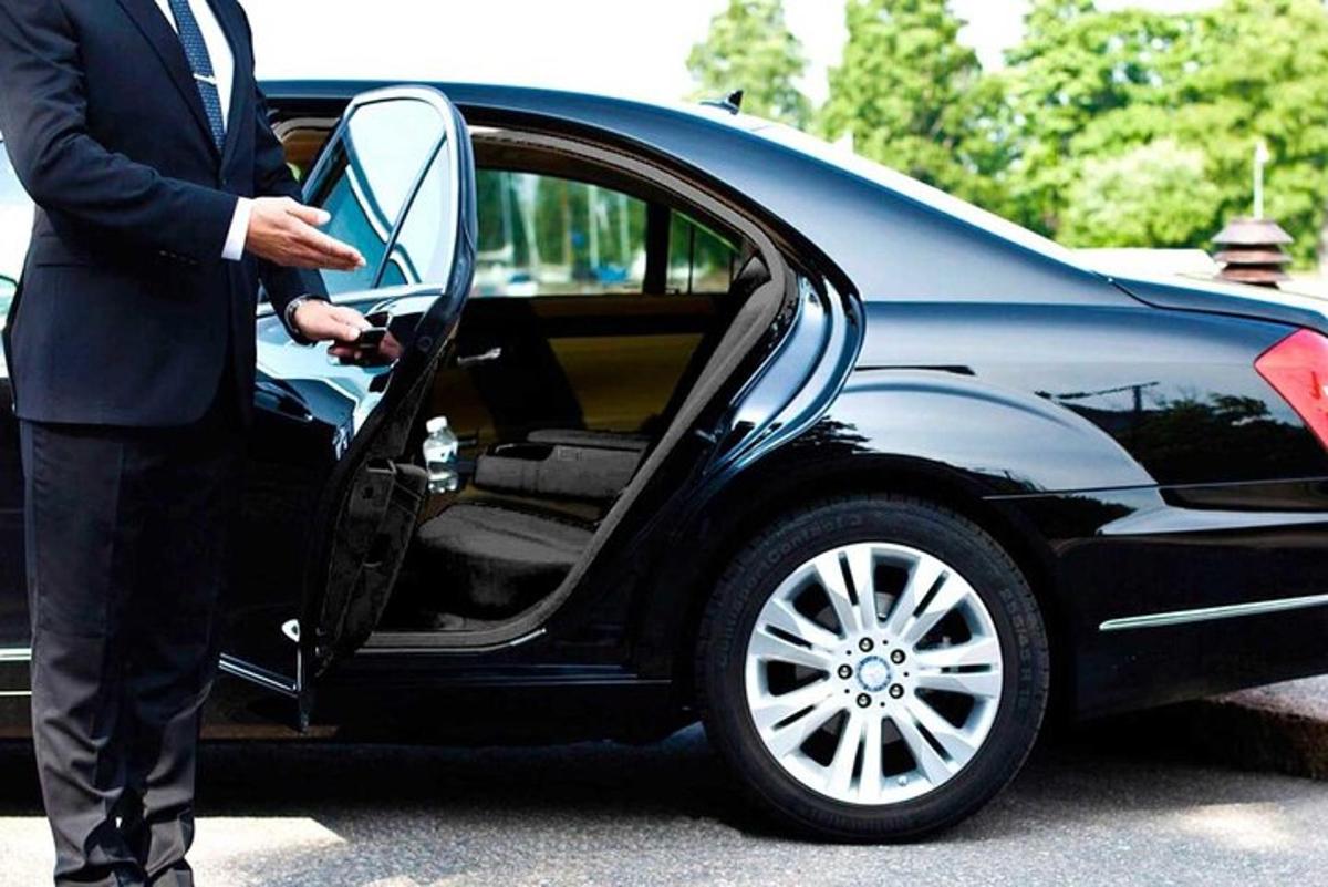 um homem de terno abrindo a porta de um carro
