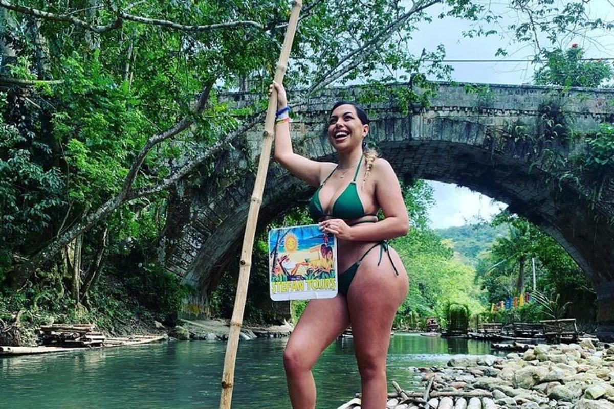 a woman in a bikini standing next to a bridge