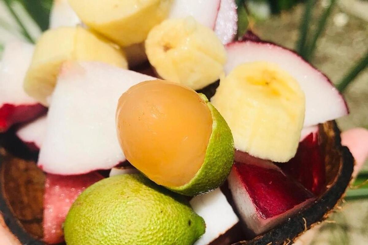 a close up of a fruit bowl with bananas and limes