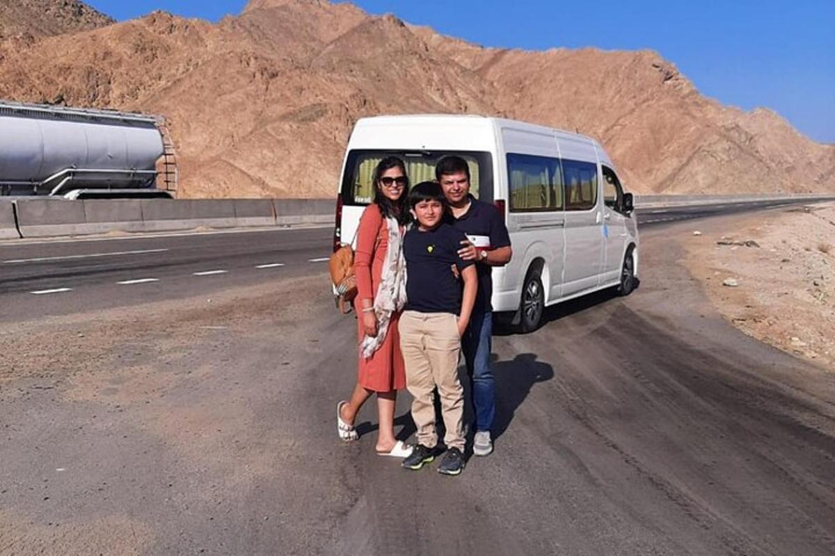 sebuah keluarga berpose di depan sebuah van di padang pasir